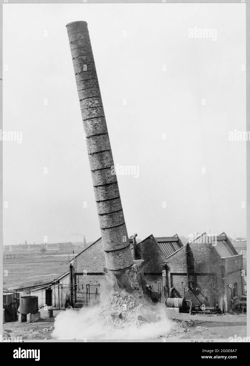 La demolizione di un camino appartenente ad una caldaia distretta, durante i lavori di preparazione del cantiere per la costruzione della raffineria di olio di Coryton. Questa immagine è stata pubblicata nell'edizione di giugno 1952 della newsletter mensile di Laing, Team Spirit. Foto Stock