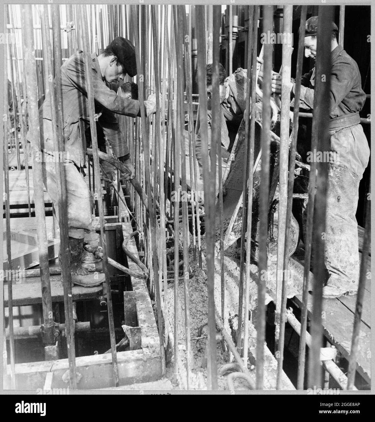 I lavoratori di Laing che versano calcestruzzo per le pareti dell'acqua di raffreddamento ingessano per la raffineria di olio di Coryton, durante la prima fase della sua costruzione a Red Lion Wharf, Gravesend. Il 30 novembre 1951, il caisson di presa di acqua di raffreddamento per la raffineria di petrolio di Coryton è stato spostato attraverso il Tamigi dal molo asciutto al molo del Red Lion Wharf, Gravesend, ai moli di Tilbury. La rimozione del cassero da Gravesend a Tilbury segnò il completamento delle prime fasi della costruzione dell'unità. La struttura è stata trainata con casseri fissi, pronti per la continuazione della cementazione a Tilbury. Foto Stock