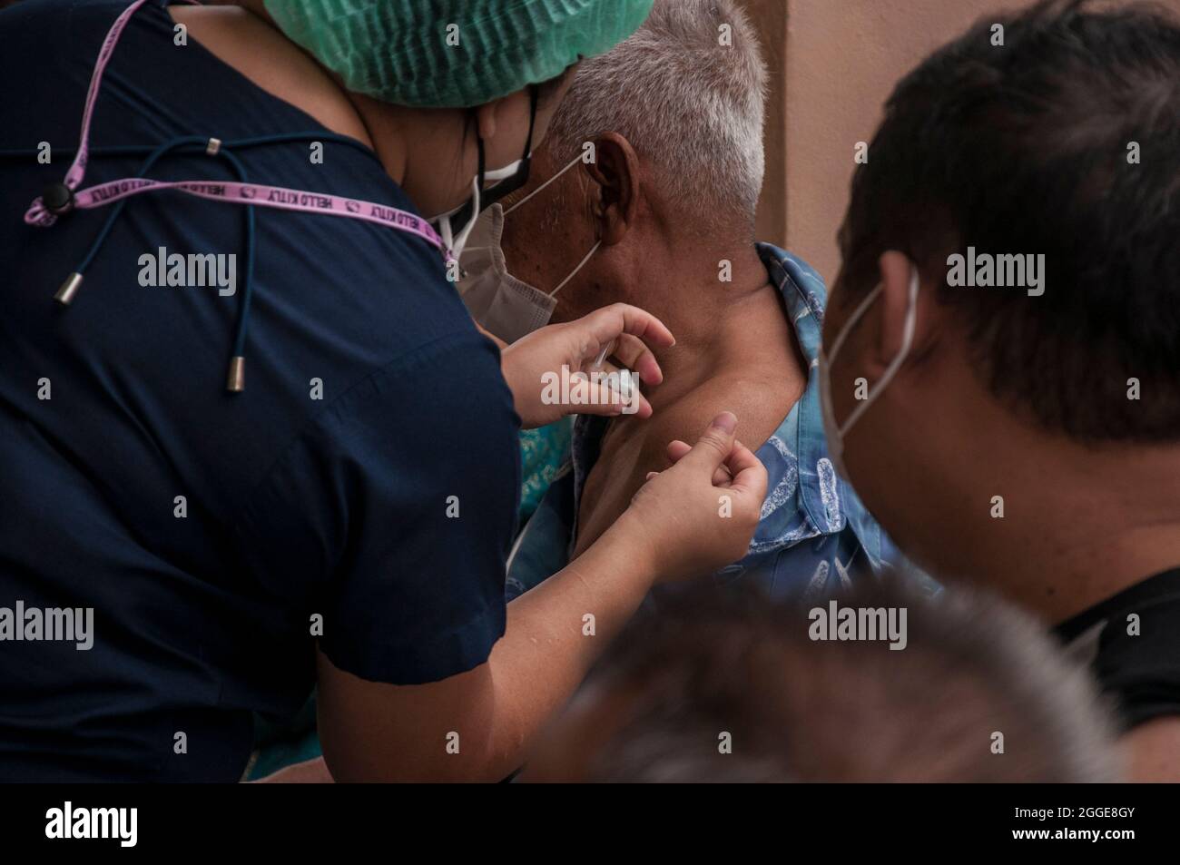 Un operatore sanitario somministra il vaccino Pfizer-BioNTech Covid-19 ad un anziano della scuola superiore Raj Pracha di Samut Prakarn.Bang Chak Hospital nella provincia di Samut Prakarn, aperto per la vaccinazione walk-in ai residenti di Samut Prakarn per ricevere la prima dose del vaccino Pfizer al Raj Pracha High, I residenti della provincia di Samut Prakarn ad alto rischio che si sono qualificati per il vaccino hanno più di 60 anni di età, sono in stato di gravidanza, o hanno condizioni preesistenti hanno ricevuto la prima dose del vaccino Pfizer-BiONTECH COVID-19 a partire dalle 8:00 e terminando alle 14:00, dal 30 agosto al 1° settembre 2021 Foto Stock