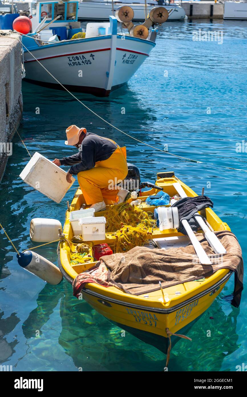 Pescatori su una piccola barca a remi nel porto di Livadia sull'isola di Tilos, Dodecaneso, Grecia Foto Stock