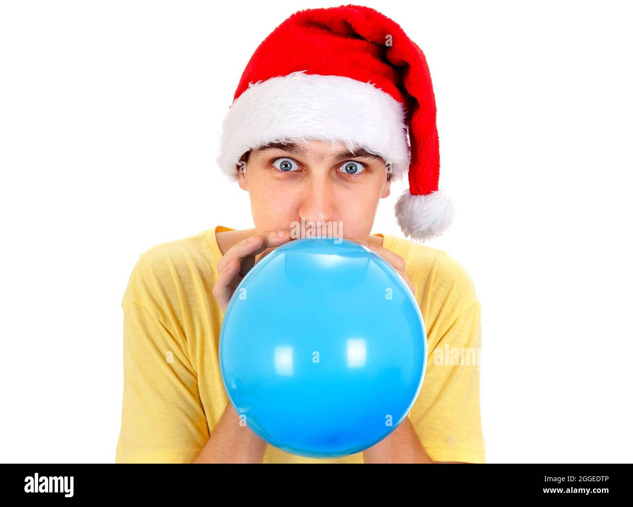 Giovane uomo a Santa Hat gonfiare un palloncino blu sullo sfondo bianco Foto Stock