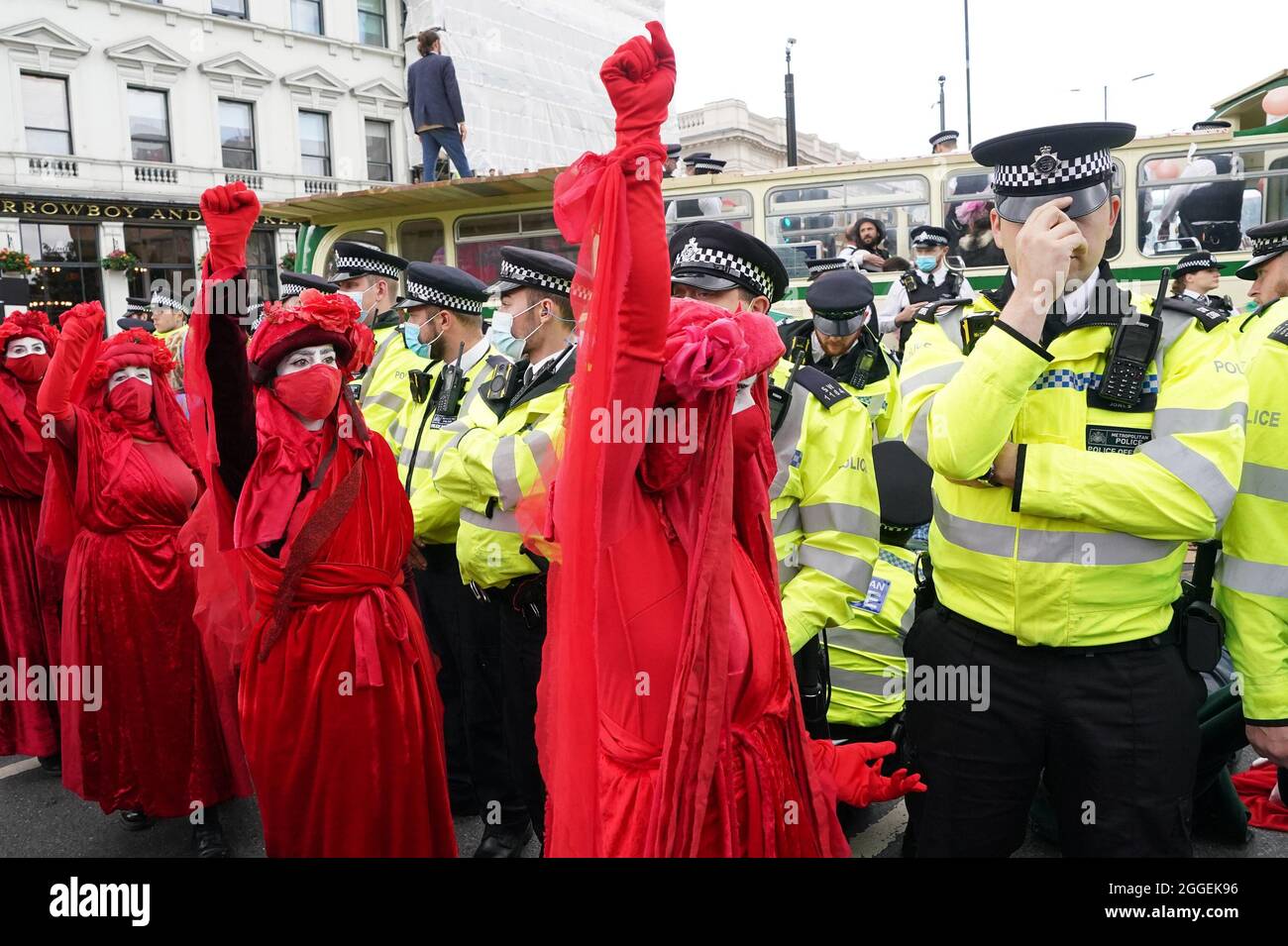 Polizia e dimostranti con un autobus parcheggiato sul London Bridge nel centro di Londra durante una protesta da parte dei membri della Rebellion di estinzione. Data foto: Martedì 31 agosto 2021. Foto Stock