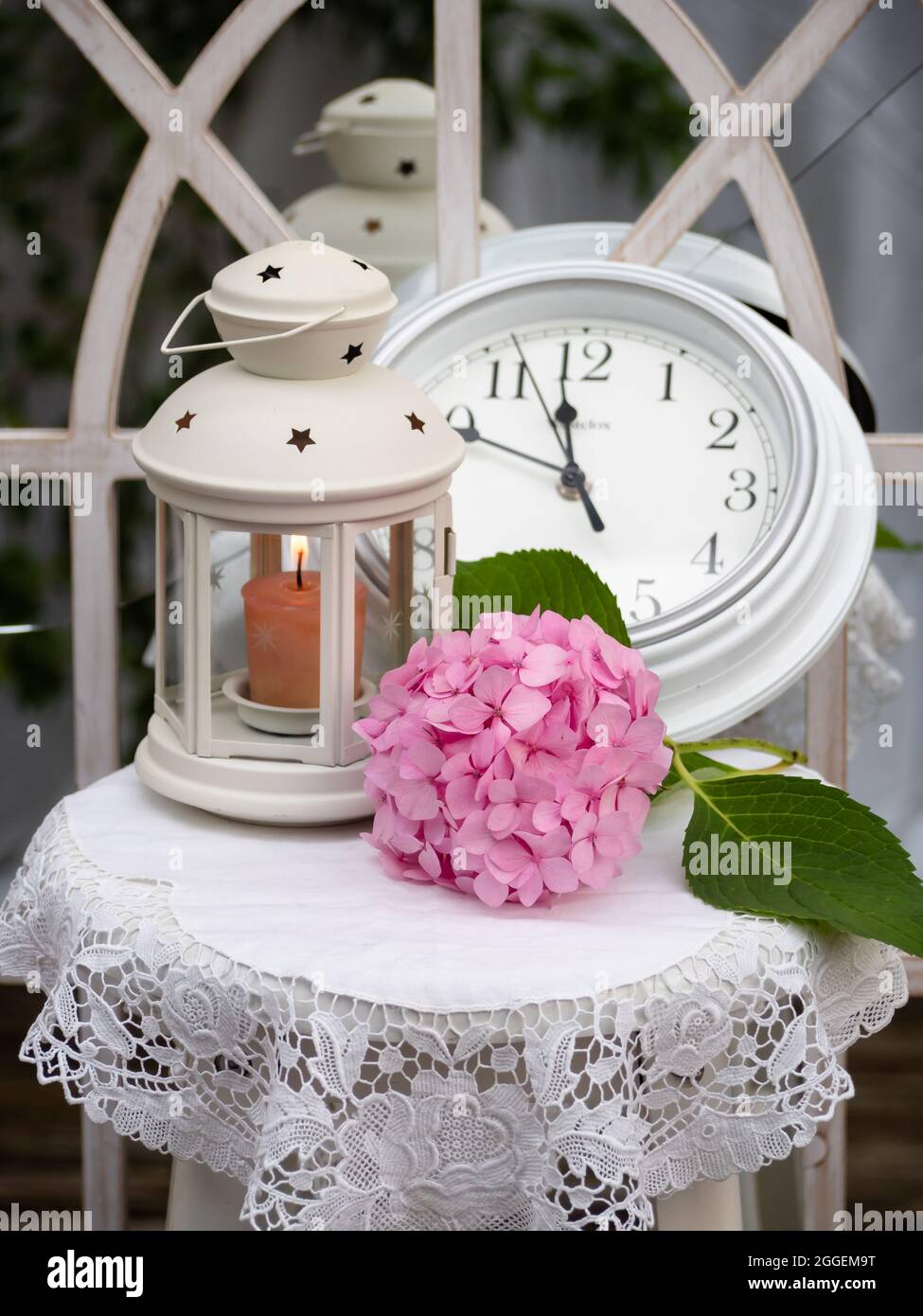 Shabby chic STILL LIFE composizione di ortangea rosa accanto a una lanterna  bianca e orologio Foto stock - Alamy