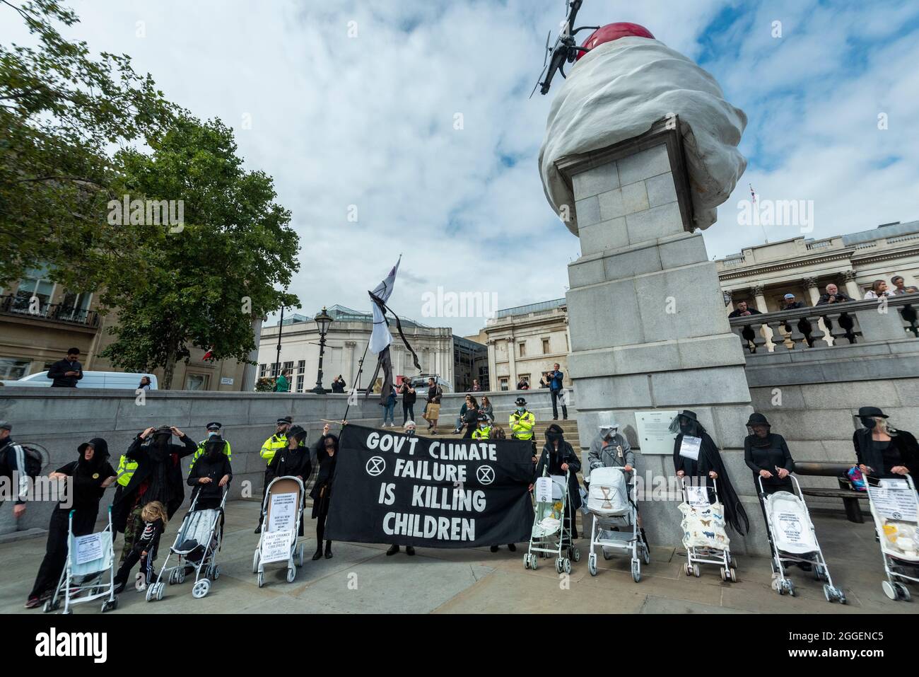 Londra, Regno Unito. 31 agosto 2021. Attivisti climatici della ribellione di estinzione, vestiti di nero e spingendo le pramme dipinte di bianco, a Trafalgar Square per evidenziare gli effetti del cambiamento climatico sui bambini e per esortare il governo a fermare i finanziamenti dei combustibili fossili. L’evento si svolge il giorno nove della protesta di due settimane “rivolta impossibile” per “individuare la causa alla radice della crisi climatica ed ecologica”. Credit: Stephen Chung / Alamy Live News Foto Stock