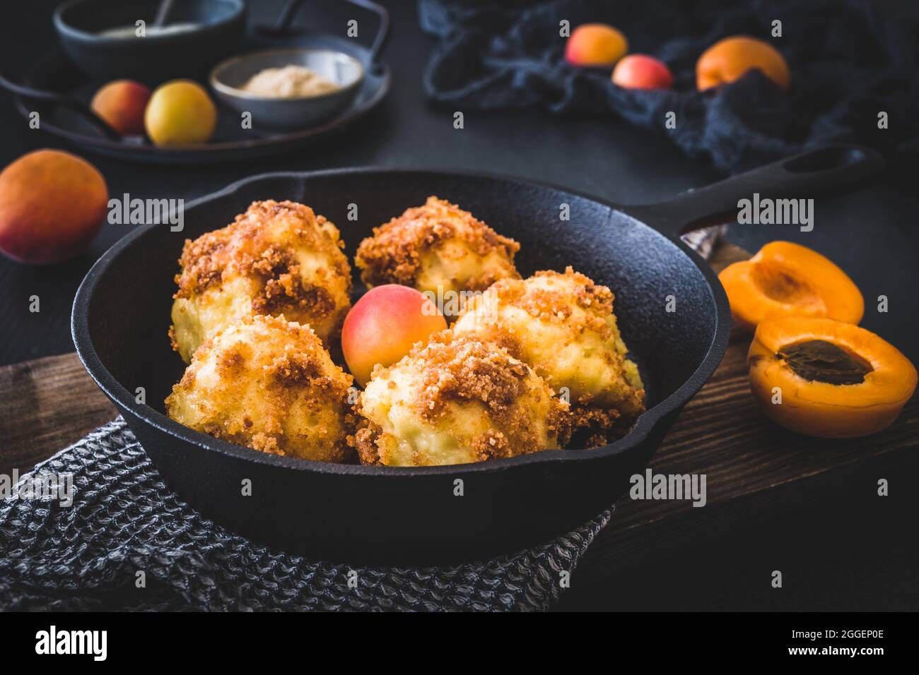 Gnocchi dolci con pangrattato dolce, ripieni di albicocche, su sfondo nero Foto Stock