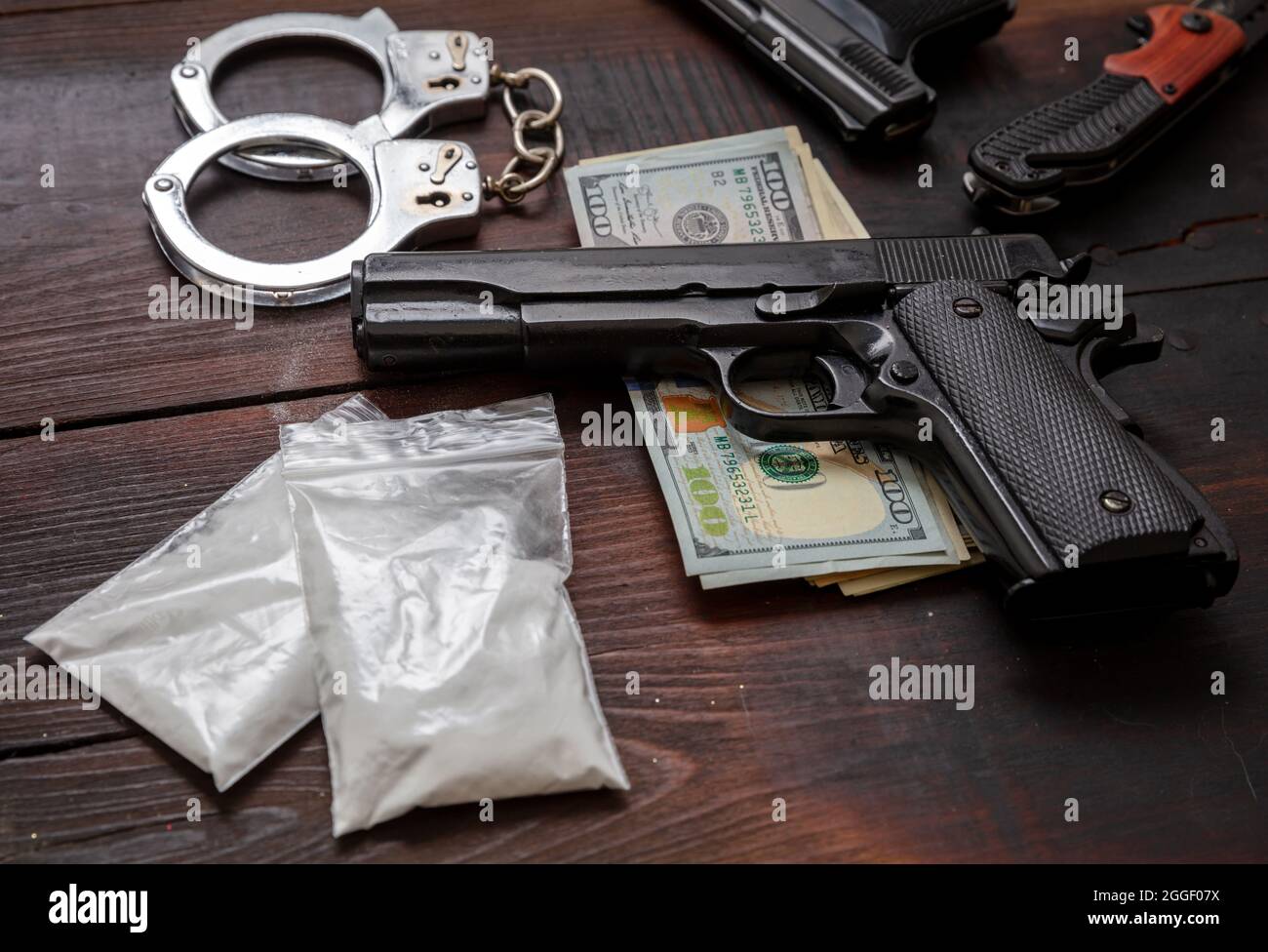 Pacchetti di plastica di cocaina, banconote in dollari USA a pistola e manette. Droga narcotici proprietà e uso, arresto e punizione per il business illegale conc Foto Stock