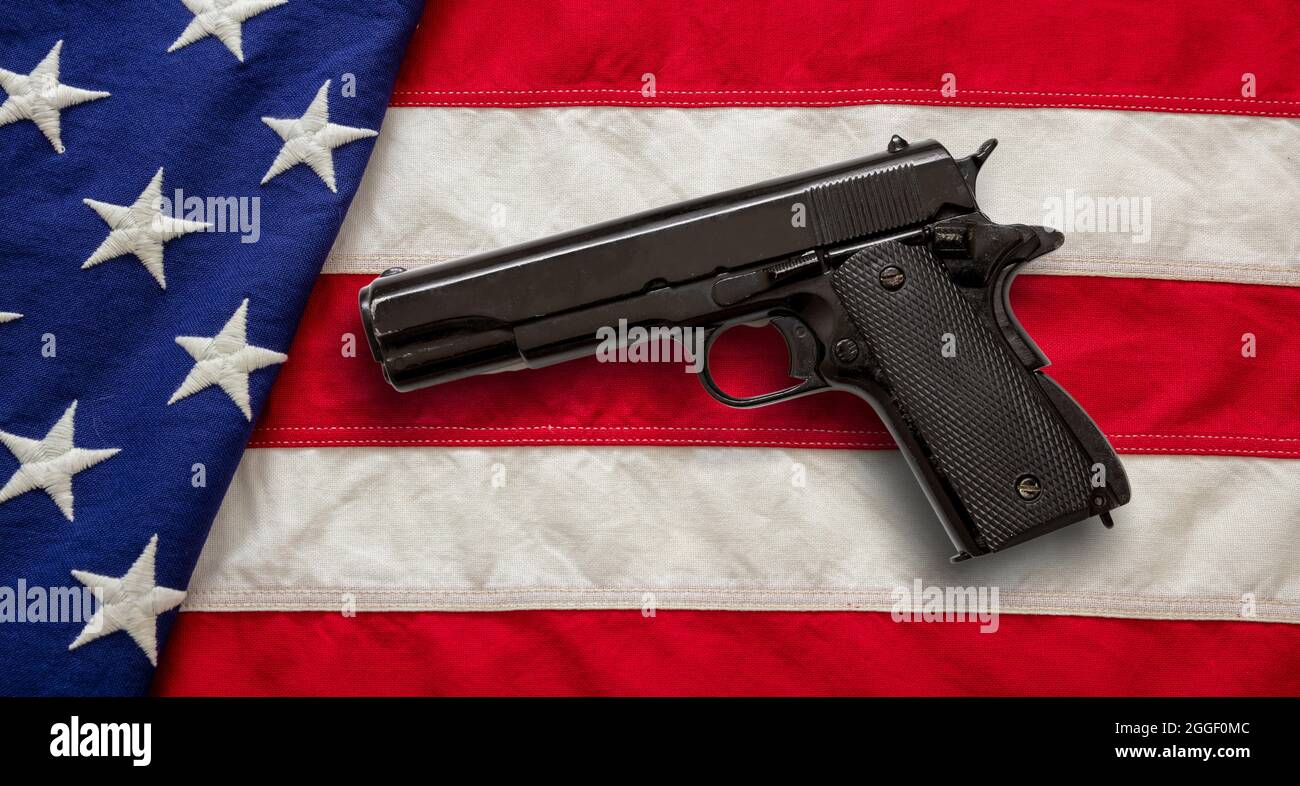 Pistola su sfondo bandiera US America, vista dall'alto. Leggi sulle armi negli stati Uniti, autodifesa e concetto di sicurezza Foto Stock