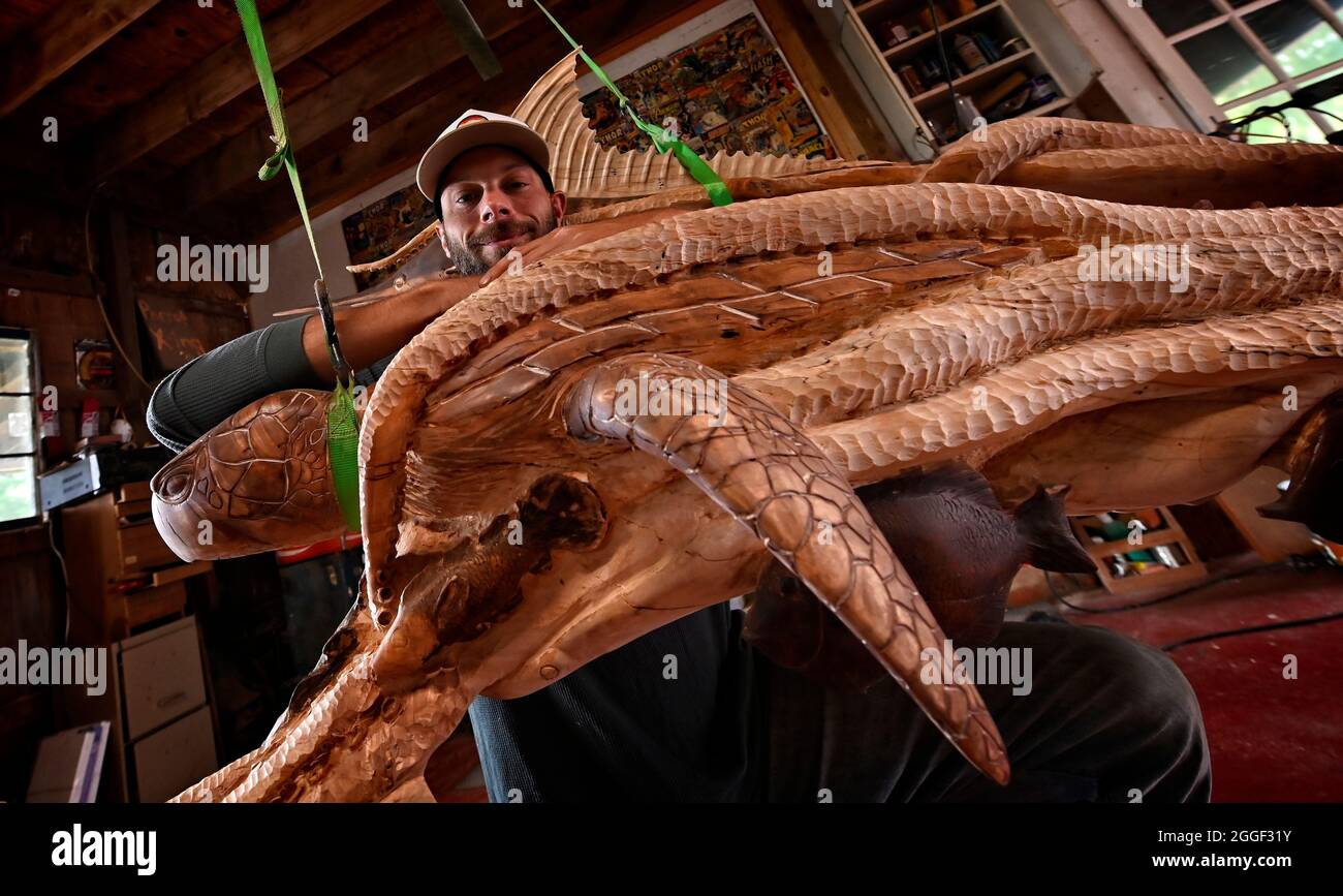 STATI UNITI - 07-26-2021: L'artista Patrick Burns pone per una foto nel suo studio con una scena nautica di polipo gigante che afferra un delfino, pesce spada Foto Stock