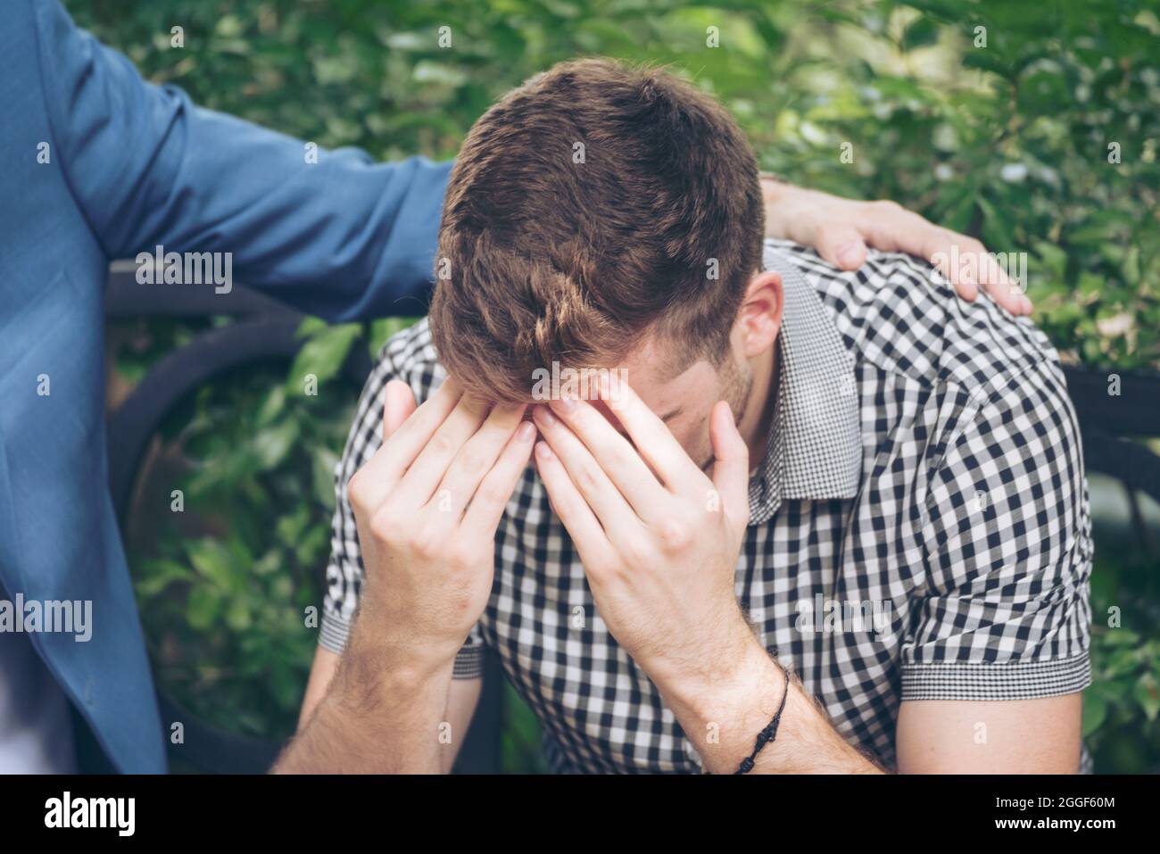 Ragazzi che condividono problemi di vita sempre supportano i migliori amici. Amici che si abbassano cuore rotto. Uomo triste seduto all'aperto nel parco sensazione di tristezza ha una p Foto Stock