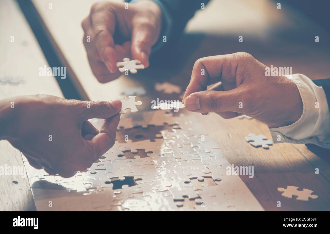 Implementare migliorare i collegamenti puzzle risolvere insieme alla strategia sinergica team building organizzare la connessione tramite la comunicazione di fiducia. Mani di stakehho Foto Stock