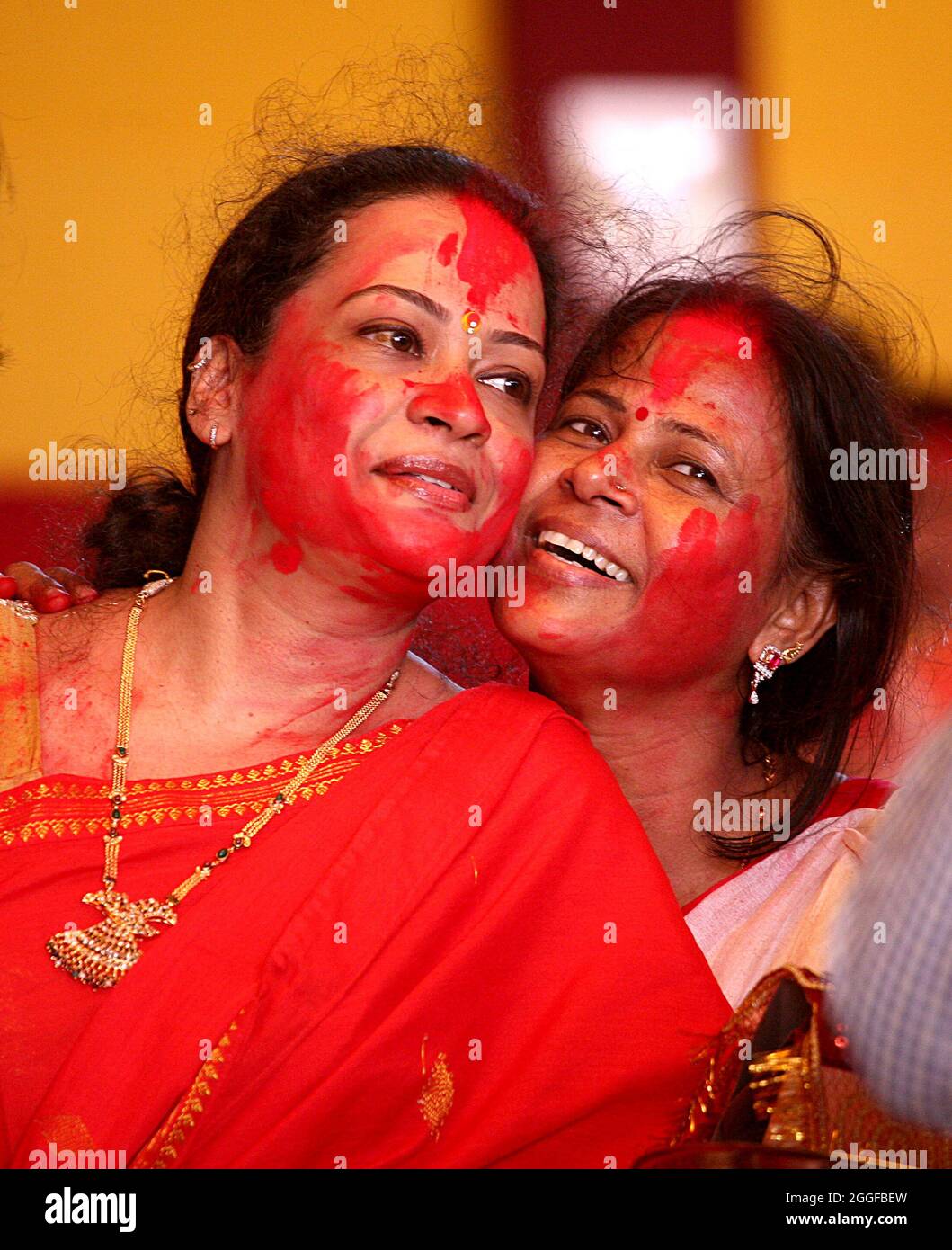 Le donne indiane bengalesi applicano vermilion su ogni altra faccia durante il khela indoor l'ultimo giorno del festival Durga Puja di 10 giorni a Nuova Delhi. Foto Stock