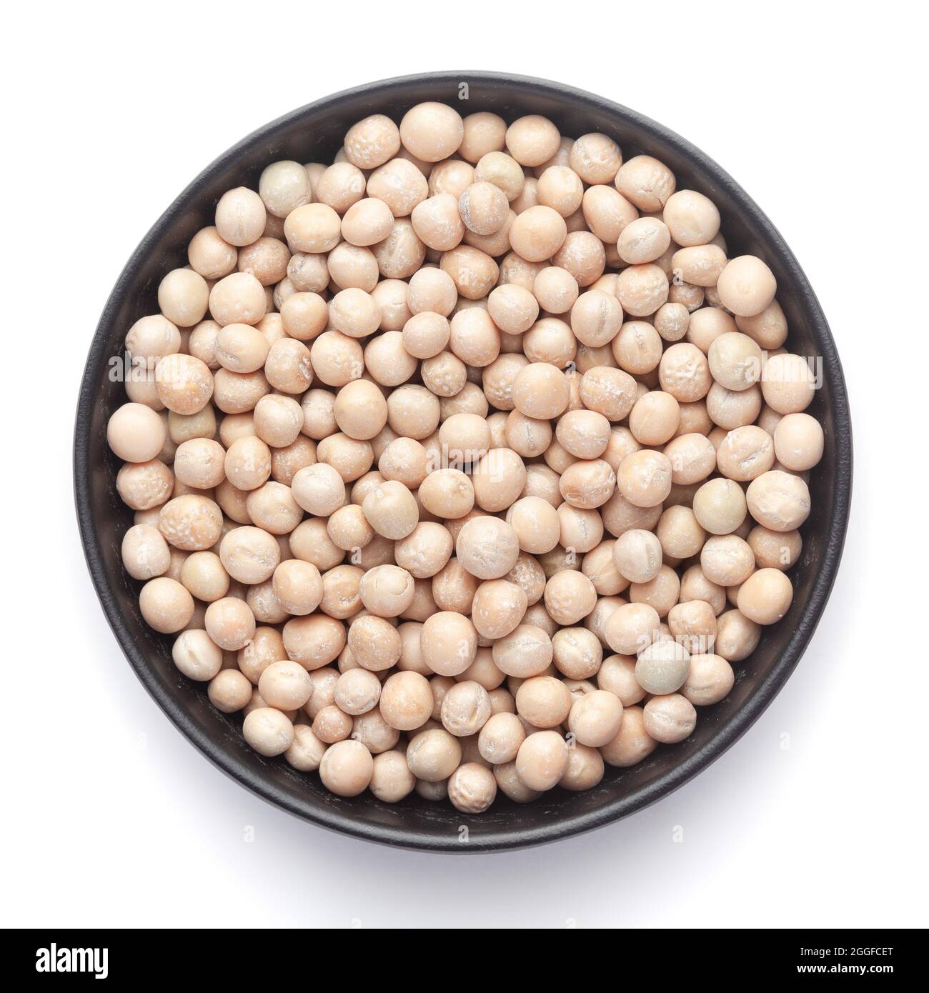 Macro primo piano di primo piano di piselli secchi organici interi (Pisum sativum) o matar dal su una ciotola nera in ceramica. Vista dall'alto Foto Stock