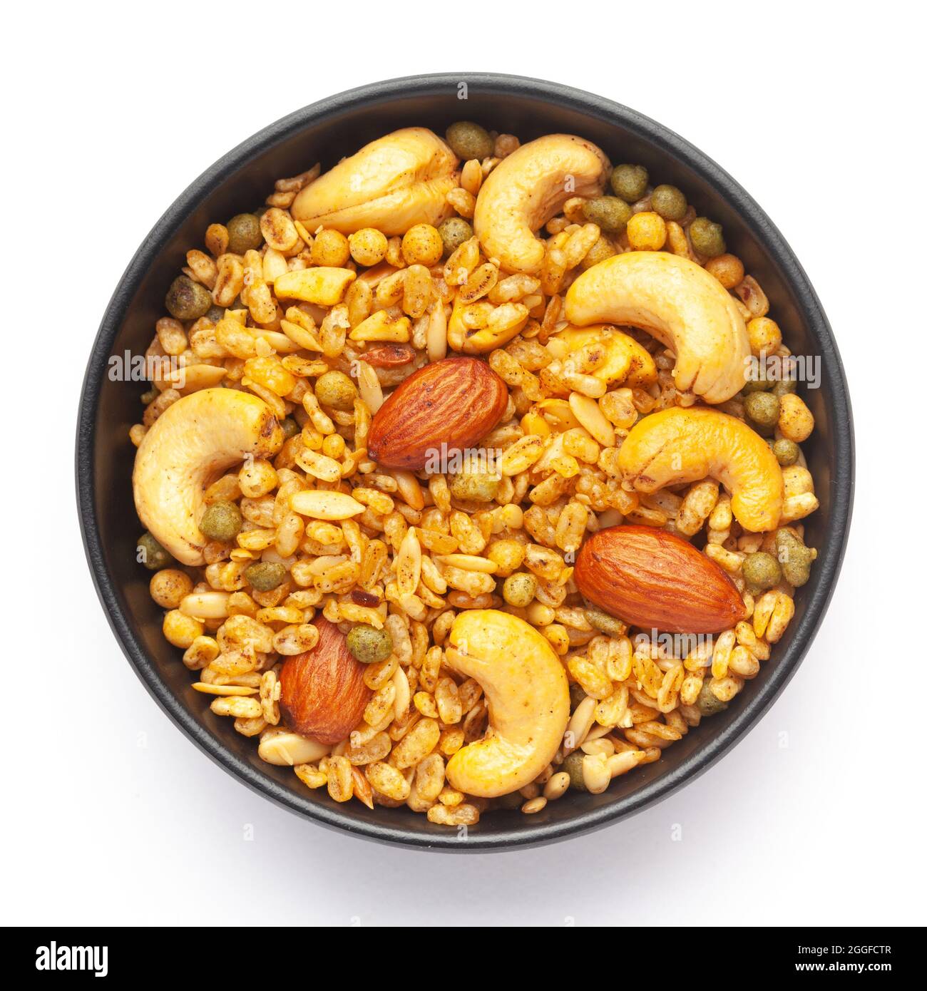 Primo piano della miscela Shahi in una ciotola di ceramica nera, fatta con arachidi, cashew, mandorle. Spuntini speziati indiani (Namkeen). Vista dall'alto Foto Stock