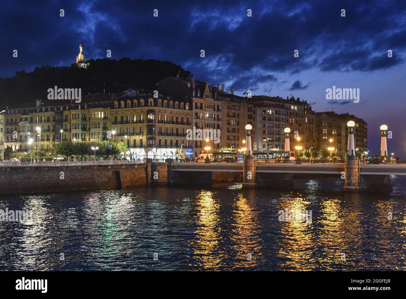 San Sebastian, Spagna - 29 ago 2021: Le luci degli edifici della città vecchia riflettono sul fiume Urumea Foto Stock