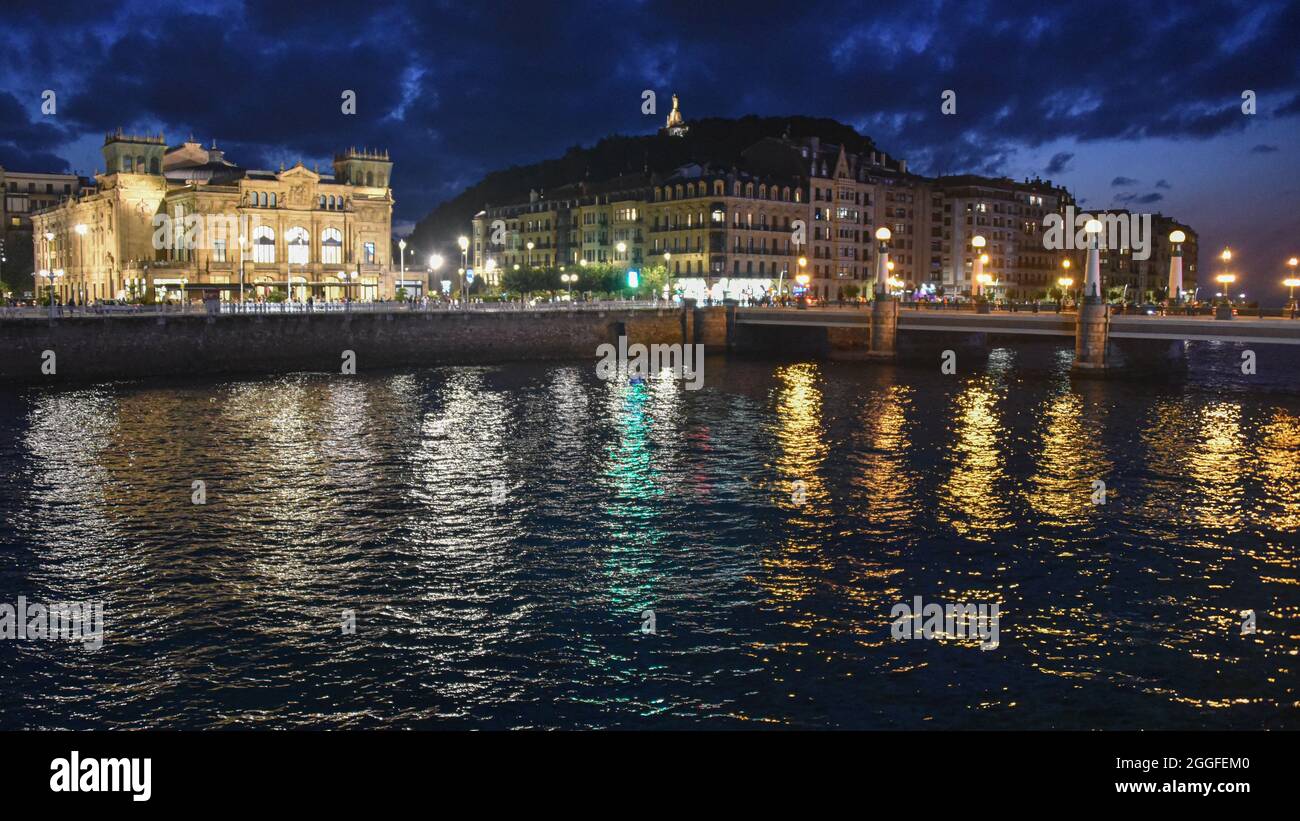 San Sebastian, Spagna - 29 ago 2021: Le luci degli edifici della città vecchia riflettono sul fiume Urumea Foto Stock