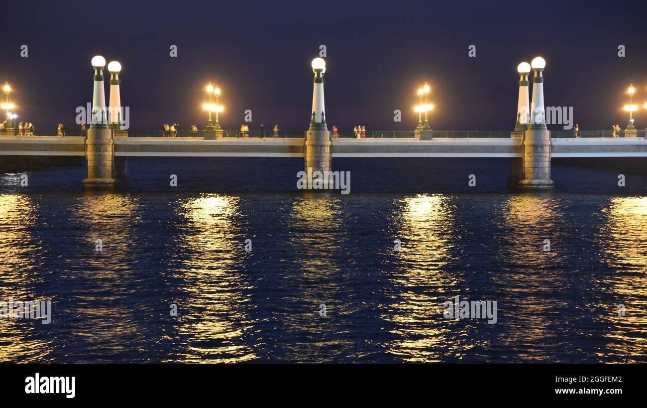 San Sebastian, Spagna - 29 ago 2021: Luci dal Ponte Kursal riflettendo sulle acque del fiume Urumea Foto Stock