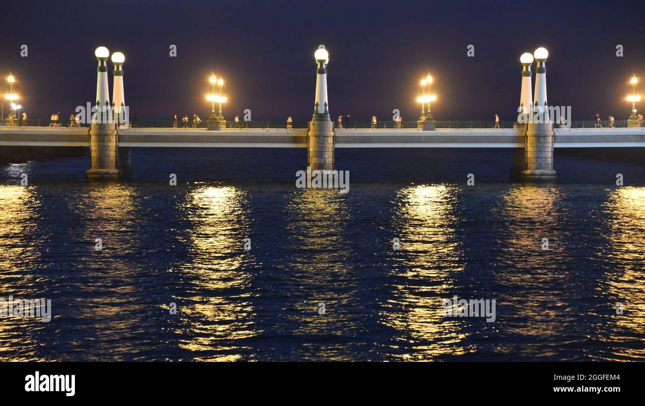 San Sebastian, Spagna - 29 ago 2021: Luci dal Ponte Kursal riflettendo sulle acque del fiume Urumea Foto Stock