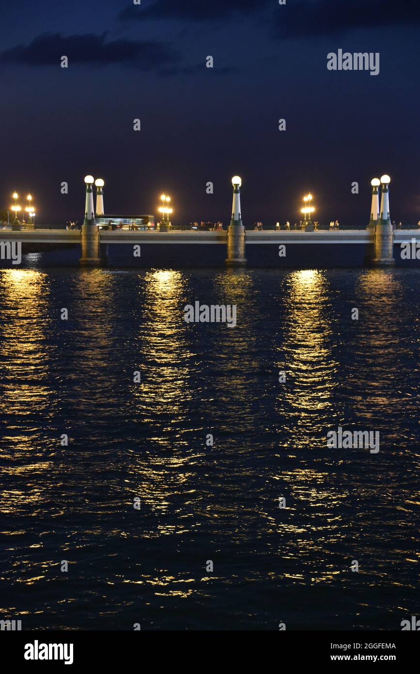San Sebastian, Spagna - 29 ago 2021: Luci dal Ponte Kursal riflettendo sulle acque del fiume Urumea Foto Stock