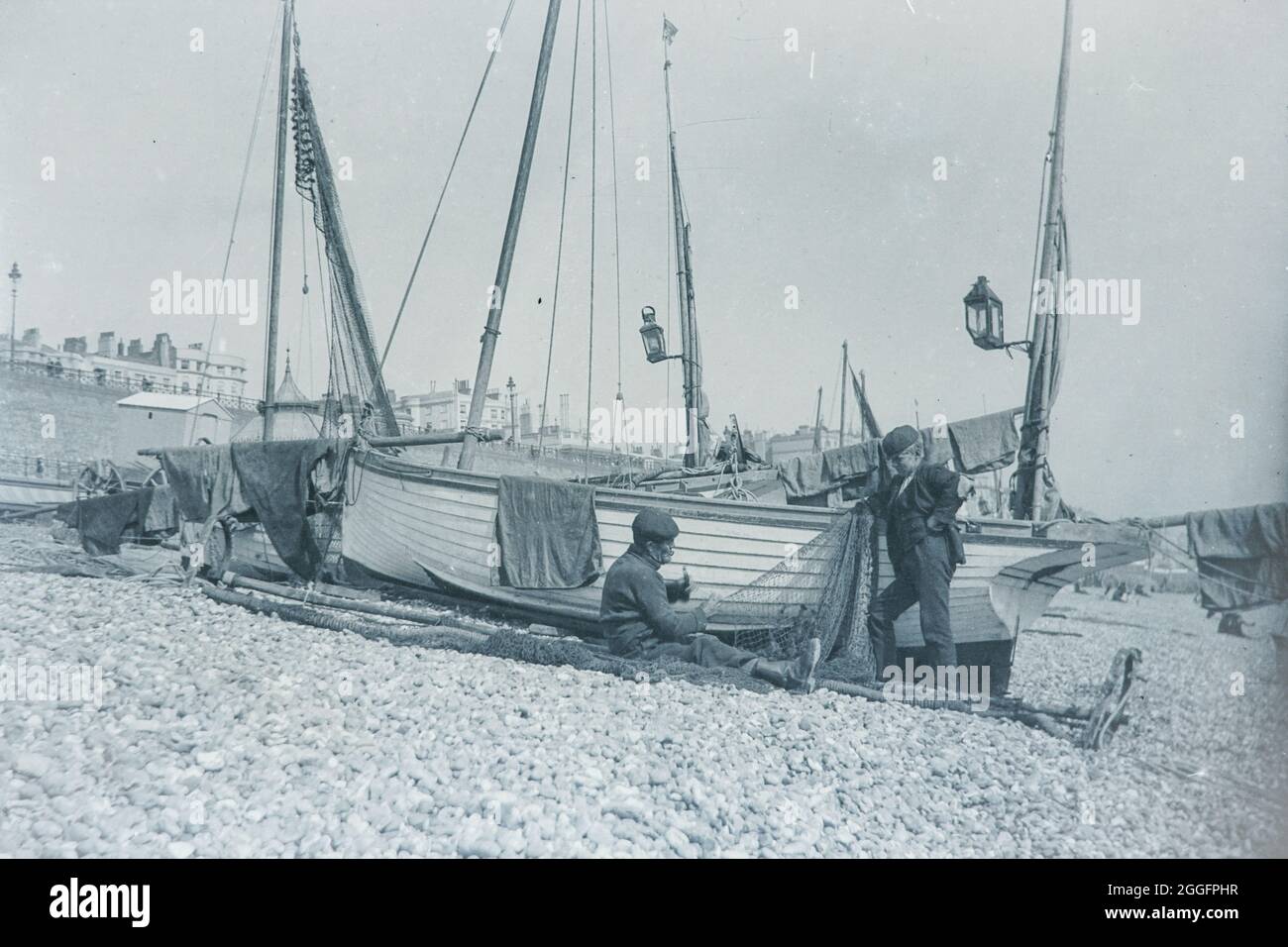 Pescatori della Edwardiana che fissano le reti per le catture di domani. Foto Stock