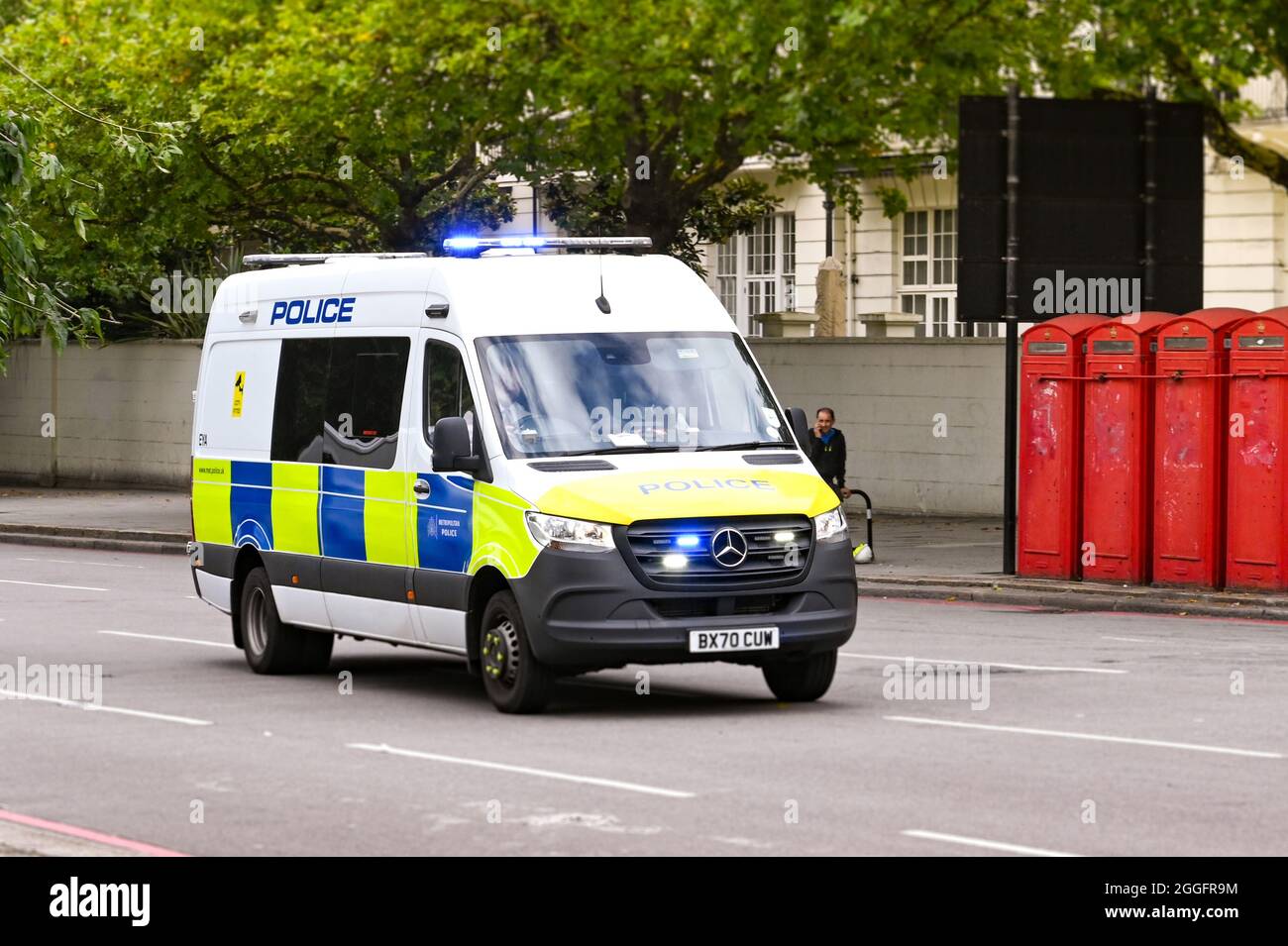 Londra, Inghilterra - Agosto 2021: Pulmino di polizia con luci blu che lampeggiano guidando lungo una strada nel centro di Londra Foto Stock