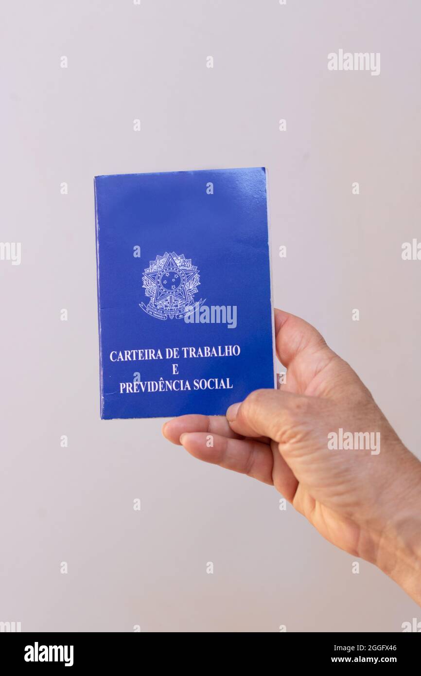 In possesso di una scheda permesso di lavoro per il brasile, isolata su sfondo bianco. Foto Stock