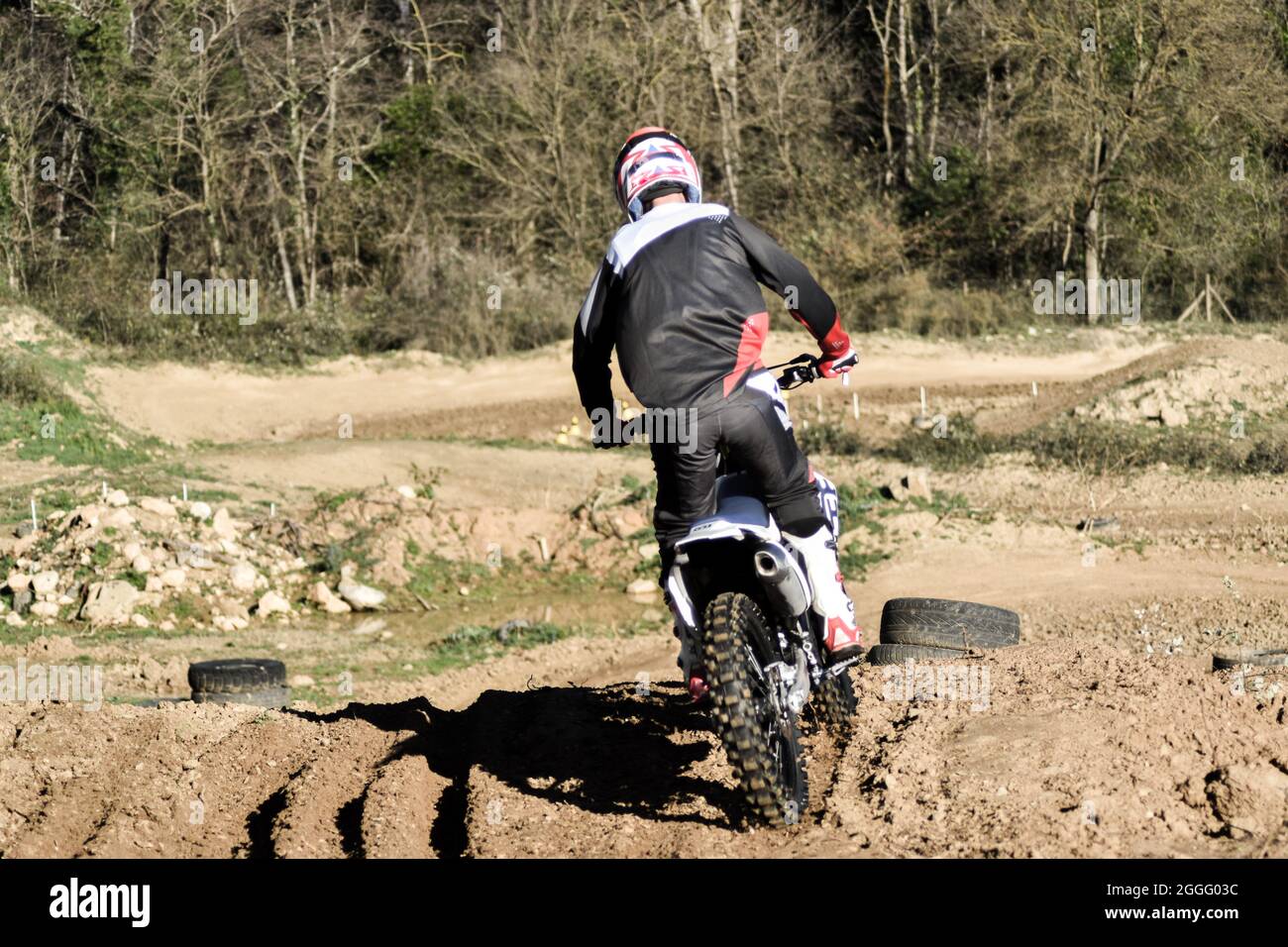 Ragazzo in tuta nera che prova un circuito da motocross Foto stock - Alamy