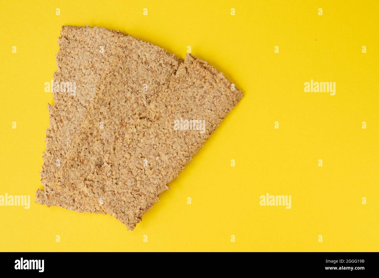 croccanti di segale multigrain marrone chiaro isolati su sfondo giallo, spuntini per cracker di pane con spazio vuoto per il testo, vista dall'alto Foto Stock