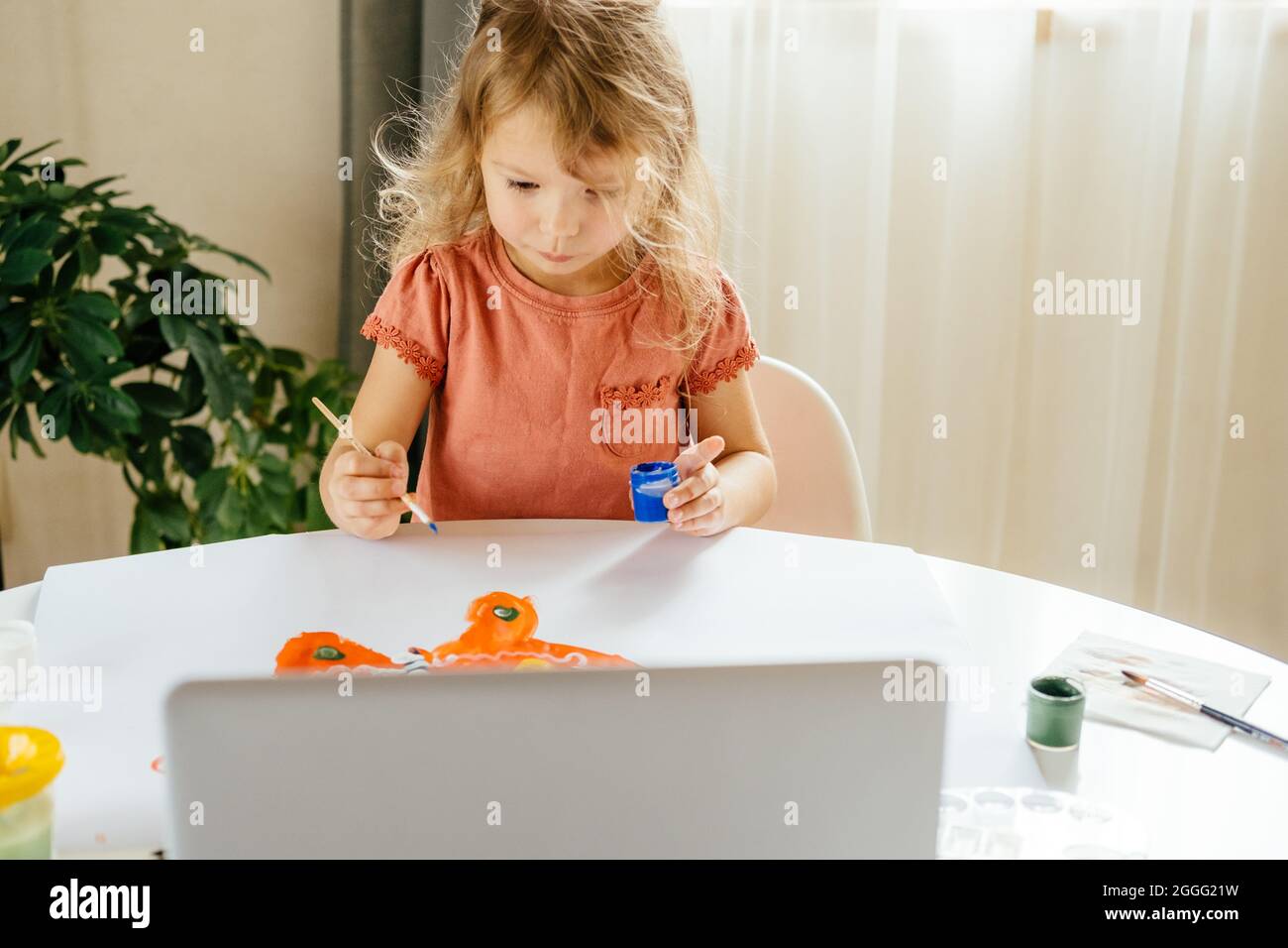 La ragazza che trascorre un po' di tempo a disegnare le vernici utilizzando un computer portatile a casa. Apprendimento a distanza, formazione online. Foto Stock