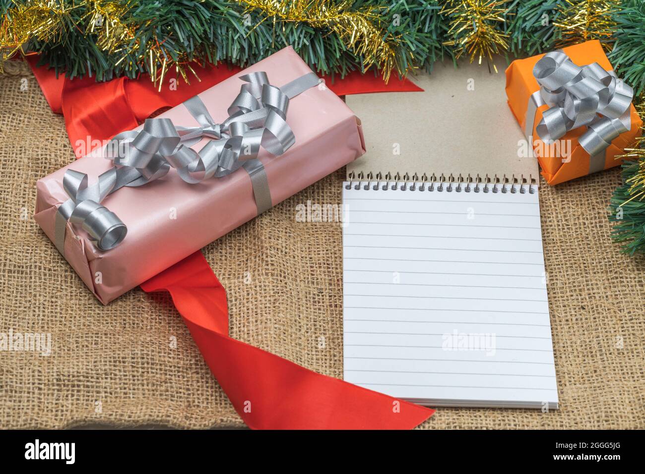 Vista dei regali imballati in scatole di festa che giacciono con la penna e desktop del libro. Concetto di vacanza di Natale. Cartolina. Svezia. Foto Stock