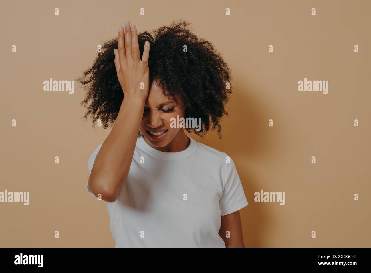 Stanco stressante donna con pelle scura che mantiene la mano sulla fronte che soffre di emicrania della testa Foto Stock