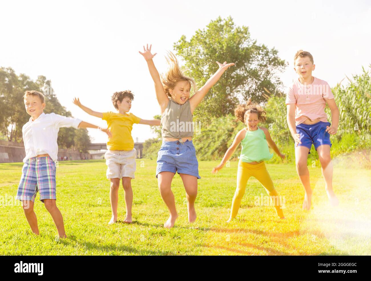 I bambini saltano e alzano le mani Foto Stock