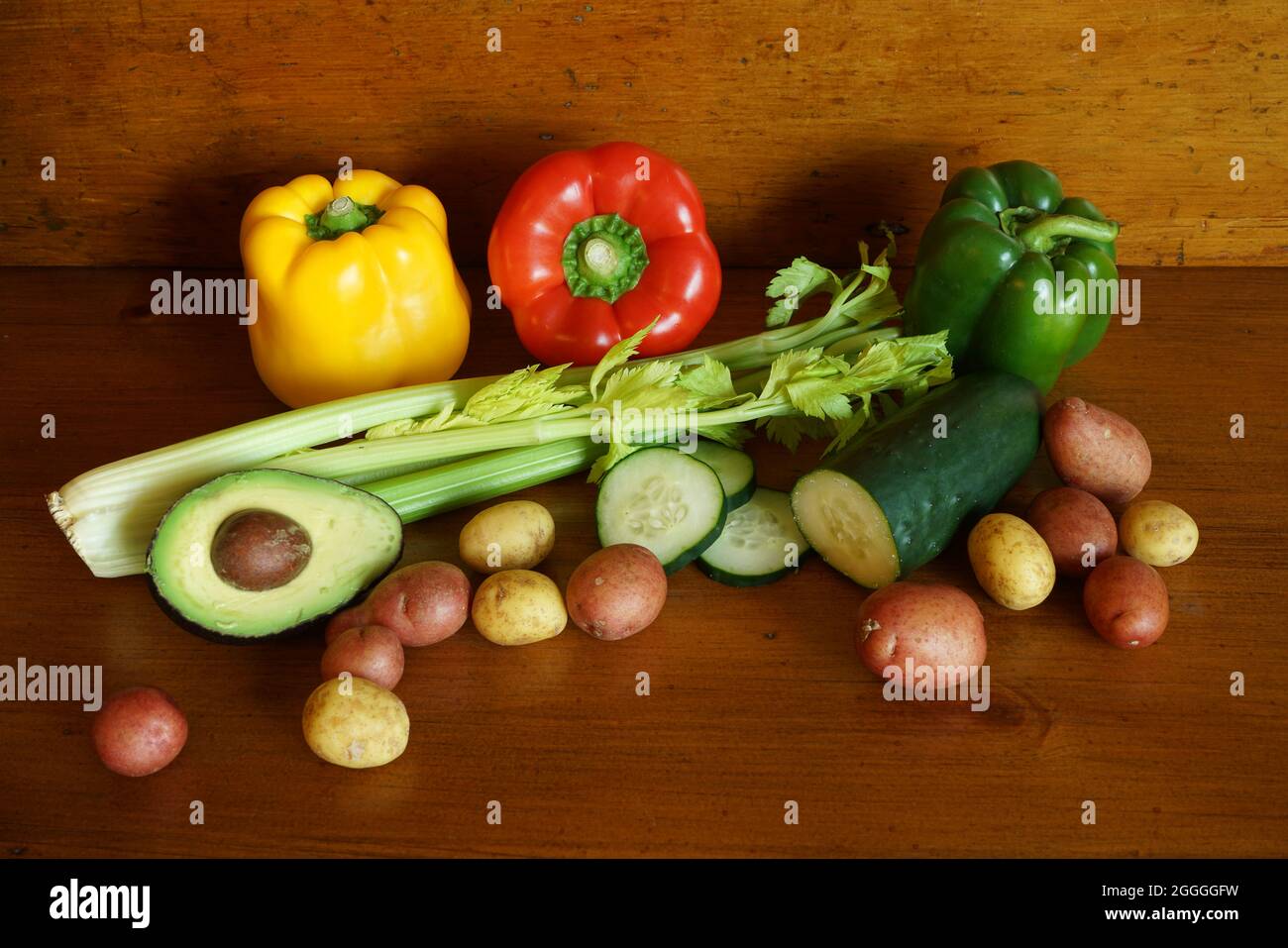 Una selezione di verdure fresche su una superficie di legno calda Foto Stock