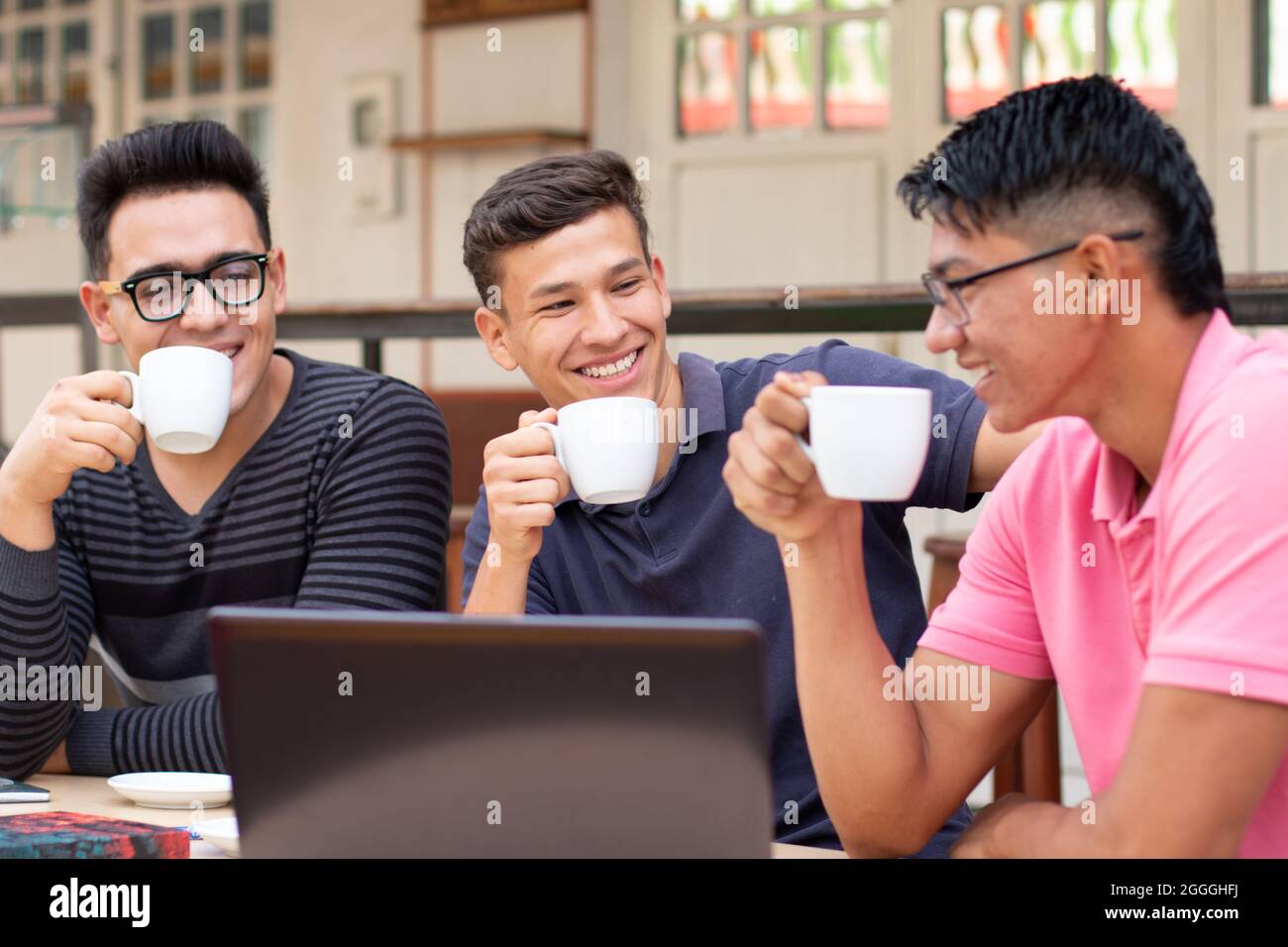 Tre studenti premurosi che bevono in un bar latino all'aperto Foto Stock