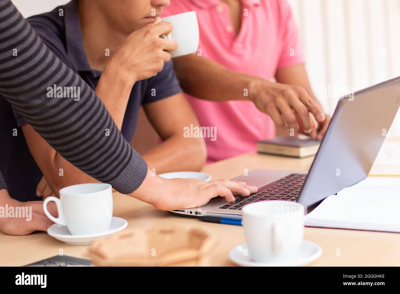 Gruppo di tre uomini d'affari che utilizzano un computer portatile sulla scrivania. Concetto di business Foto Stock