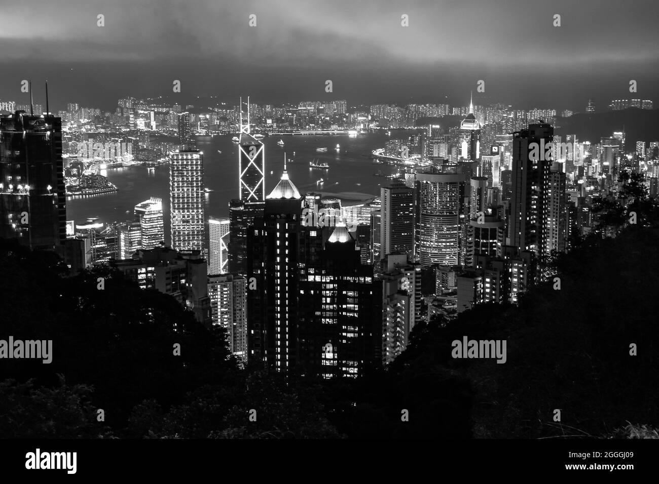 Iconica vista notturna di Hong Kong e Victoria Harbour dalla piattaforma di osservazione Victoria Peak (versione in bianco e nero) Foto Stock