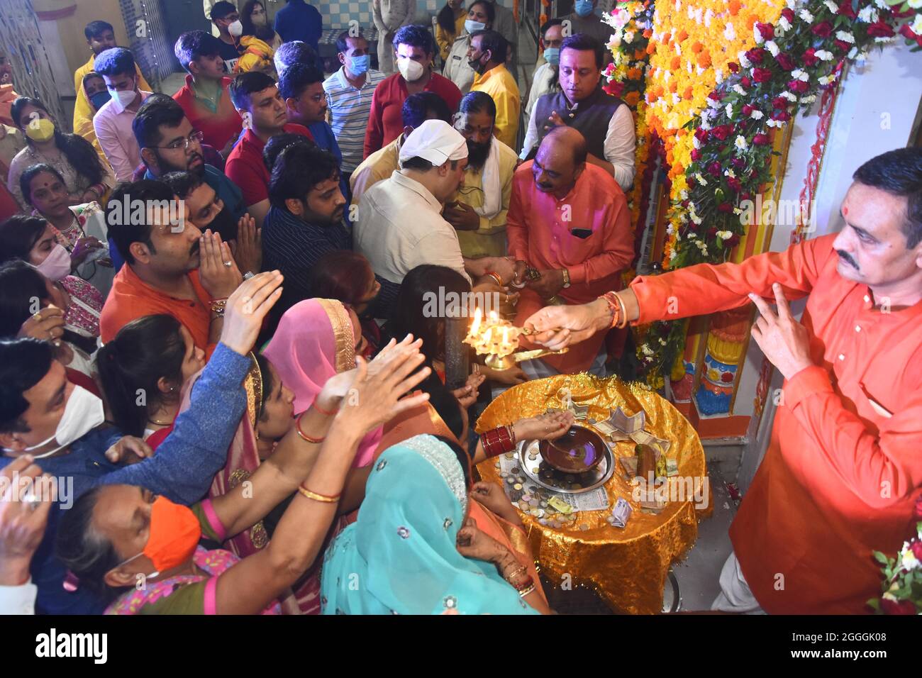 I devoti indù indiani si uniscono alle loro mani in preghiera mentre si trovano davanti a una statua del Dio indù Krishna, al Tempio di Jabalpur, Foto Stock