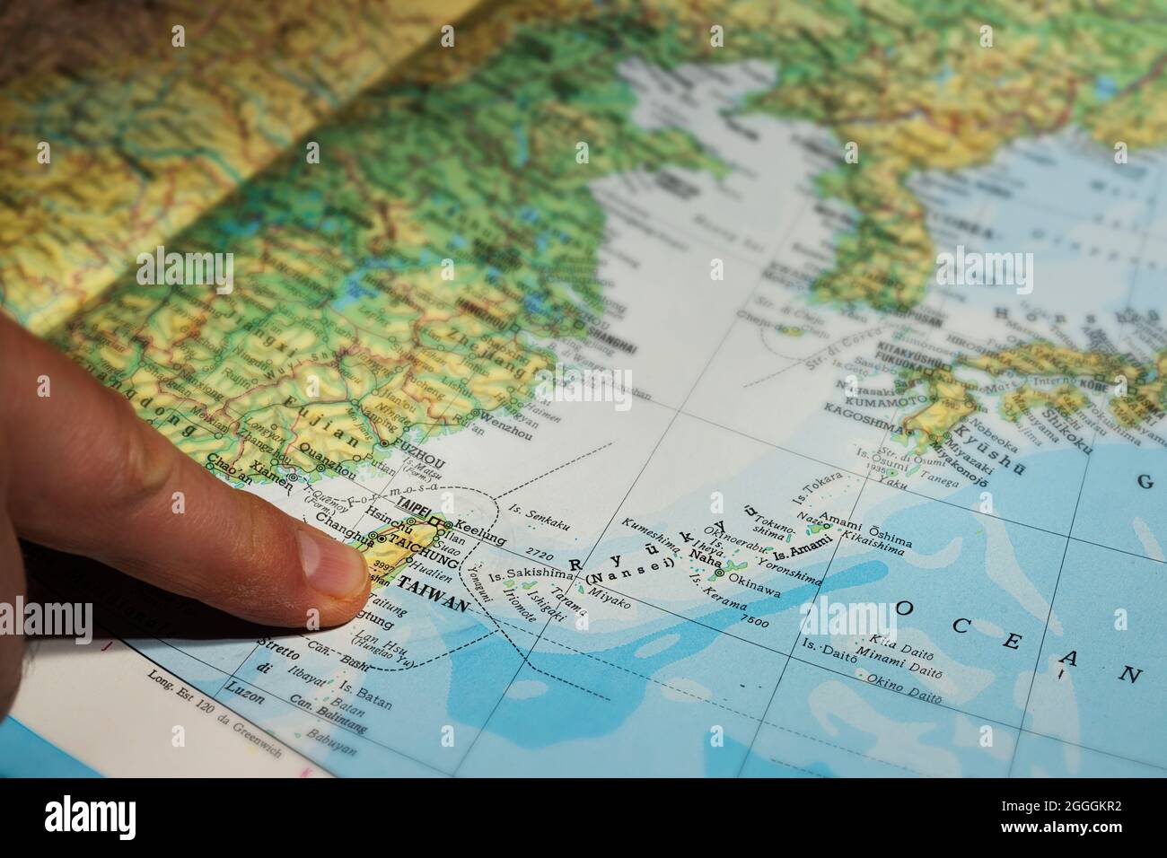 Udine, Italia. 7 agosto 2021. Un uomo punta all'isola di Taiwan su una mappa nella giornata nazionale cinese Foto Stock