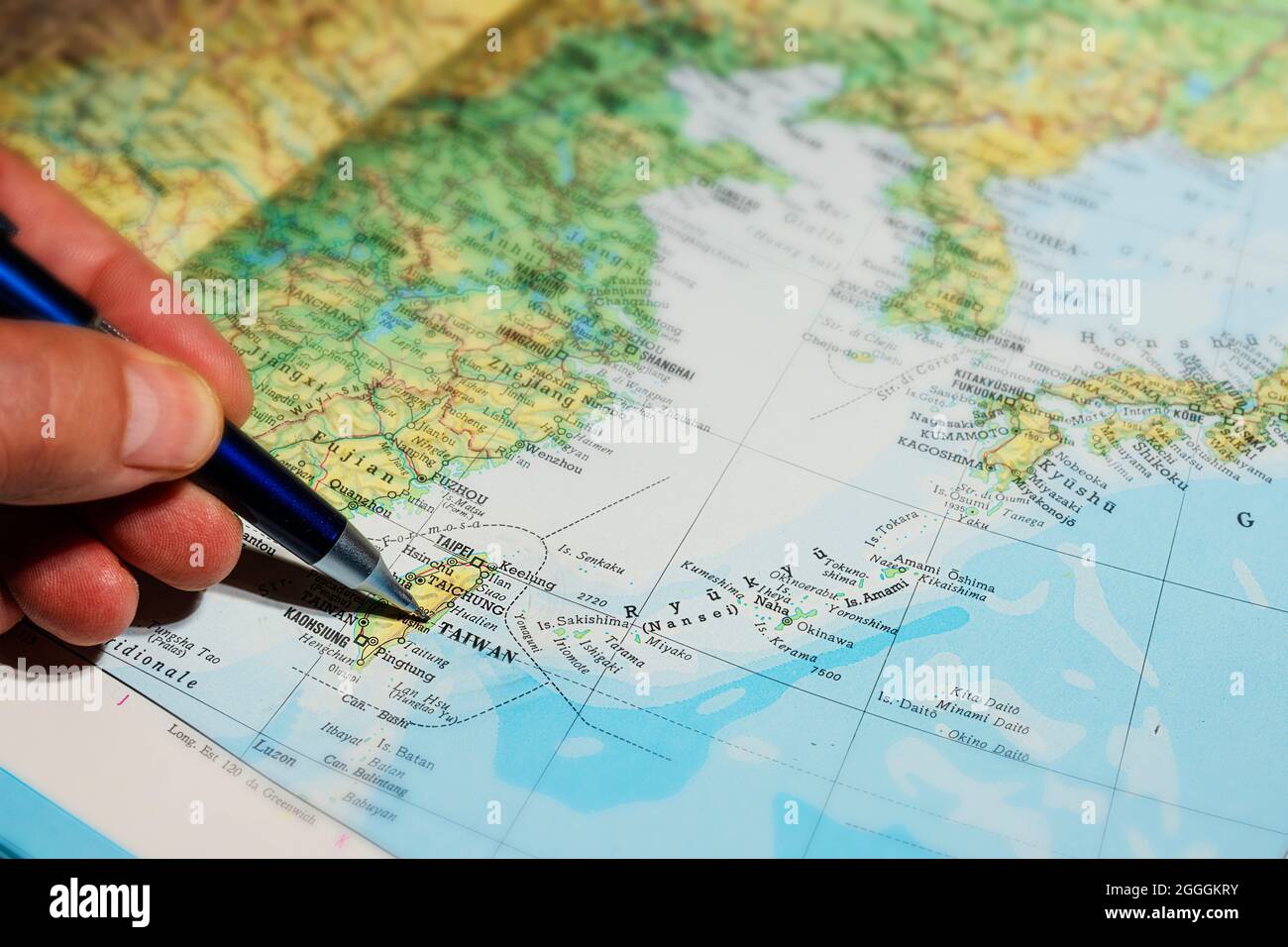 Udine, Italia. 7 agosto 2021. Un uomo punta all'isola di Taiwan su una mappa nella giornata nazionale cinese Foto Stock