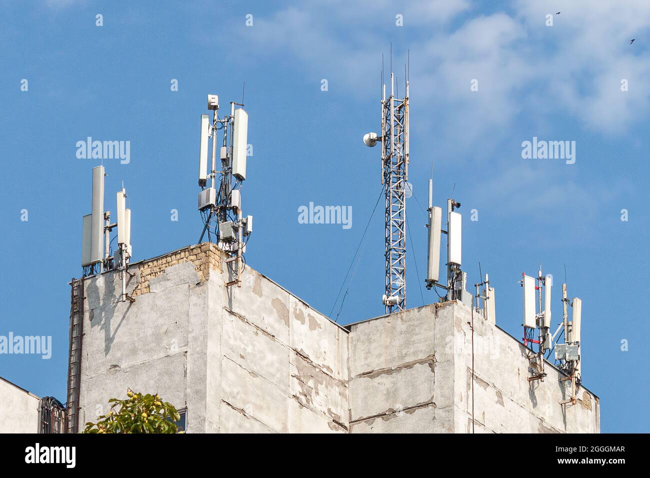 Torre di telecomunicazione con antenna di rete cellulare 5G su sfondo urbano Foto Stock