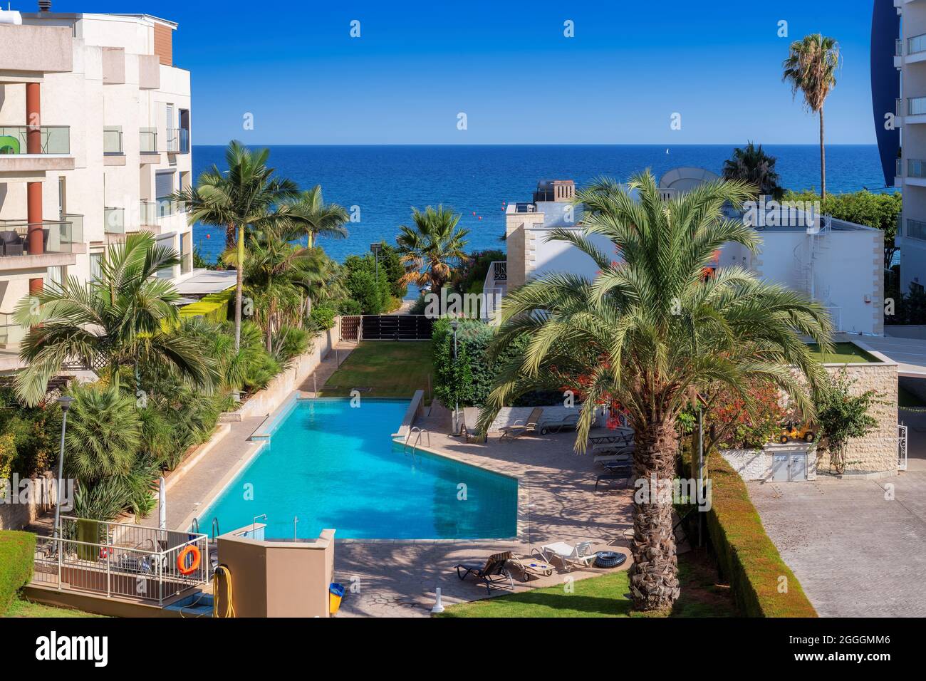 Vista aerea della costa di Cipro con piscina blu, palme e spiaggia nel mare Mediterraneo, Limassol, Cipro Foto Stock