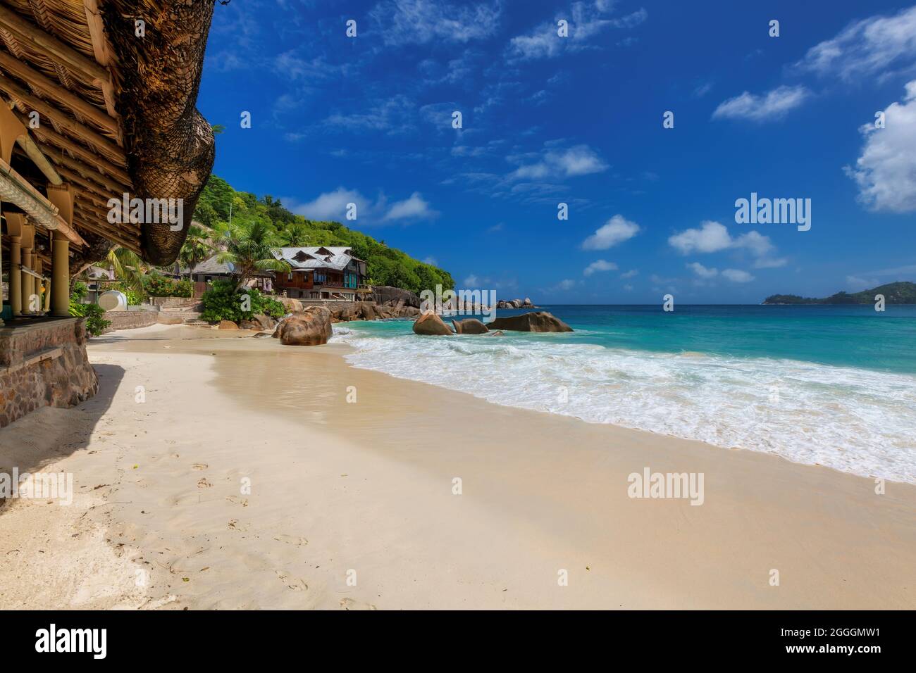 Resort tropicale con ristorante all'aperto sulla spiaggia tropicale con onde oceaniche Foto Stock