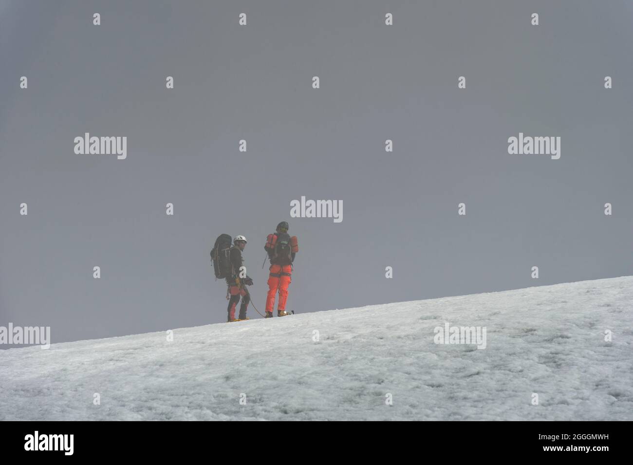 Due alpinisti nella nebbia sul ghiacciaio Turtman, Zinal, Val d’Anniviers, Wallis, Svizzera Foto Stock