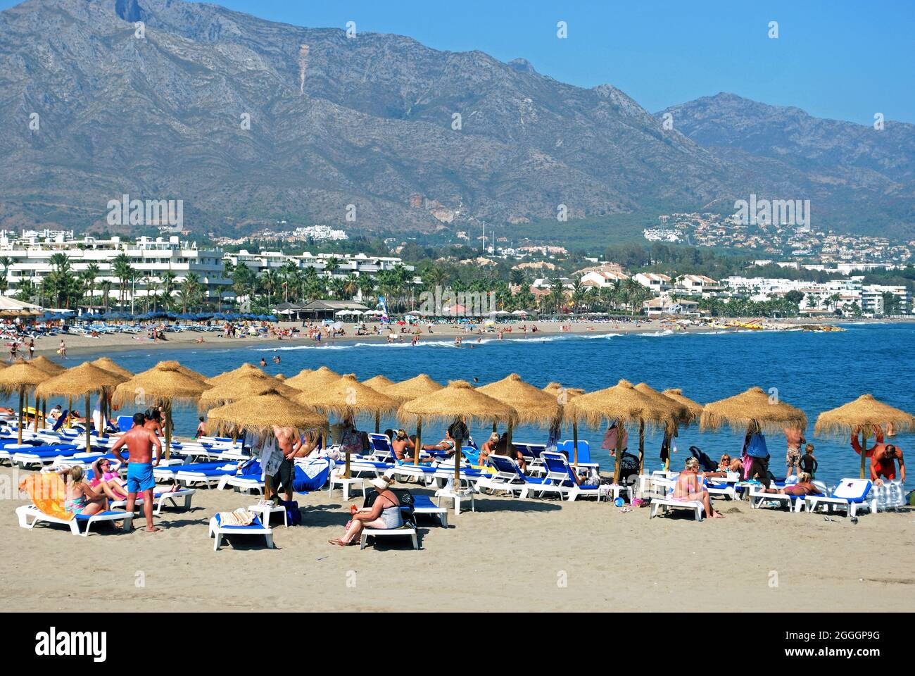 Vista della spiaggia e della costa di Puerto Banus con i turisti che si godono il sole, Marbella, Spagna. Foto Stock
