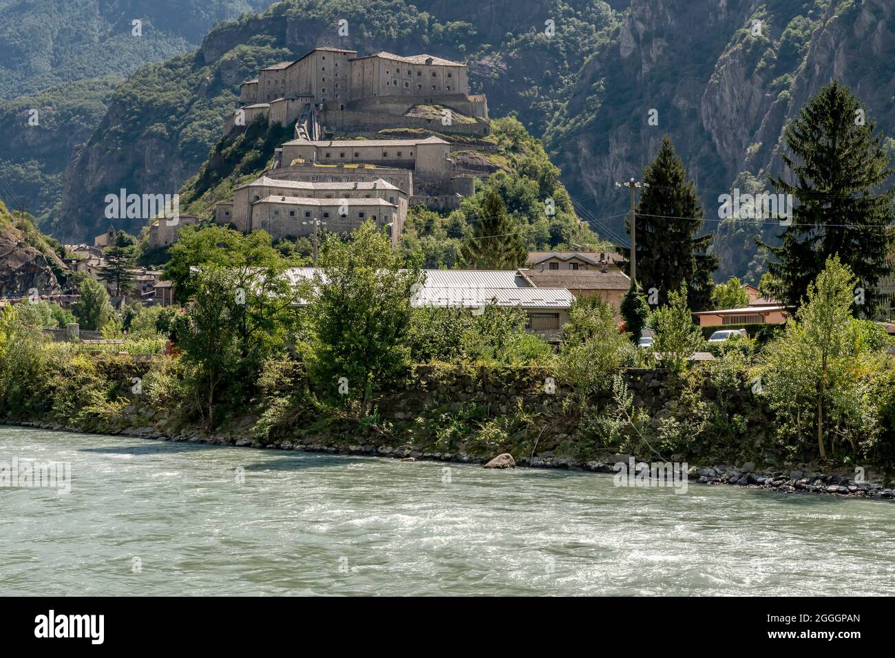 Il fiume Dora Baltea scorre sotto la collina del Forte di Bard, Valle d'Aosta, Italia Foto Stock