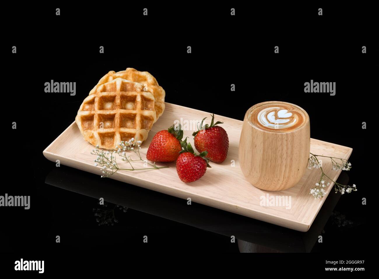 Waffle con fragole fresche e una tazza di cappuccino. Foto Stock