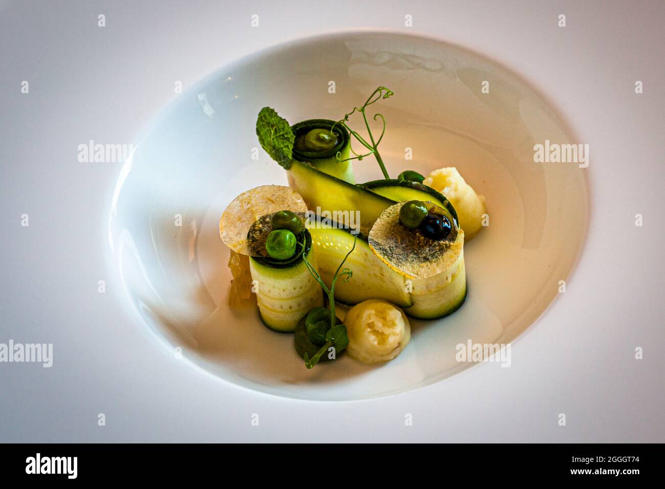 Piatto gourmet all'Hotel Hohenwart di scena, Italia. Zucchine e piselli con purea di cipolla tostata Foto Stock