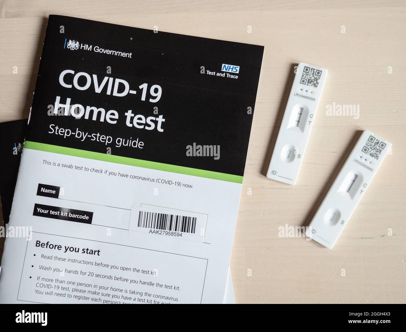 Risultato positivo del test COVID-19. Risultati dei test sia positivi che negativi di un kit per test domestico del virus corona a flusso laterale NHS del Regno Unito con manuale dell'utente. Foto Stock