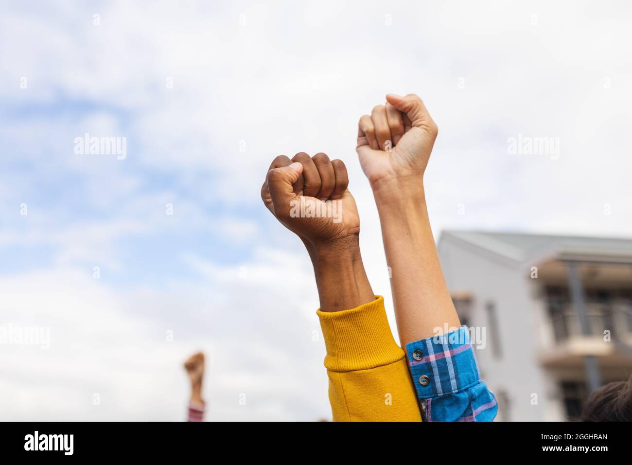 Diverse persone che alzano i loro pugni in una marcia di protesta Foto Stock
