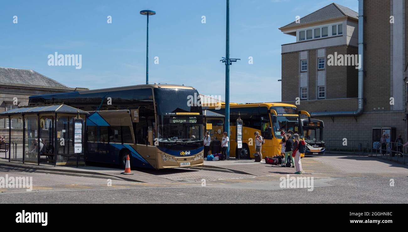 Passeggeri in attesa di salire a bordo di un autobus alla stazione degli autobus di Inverness, Inverness, Scozia Foto Stock