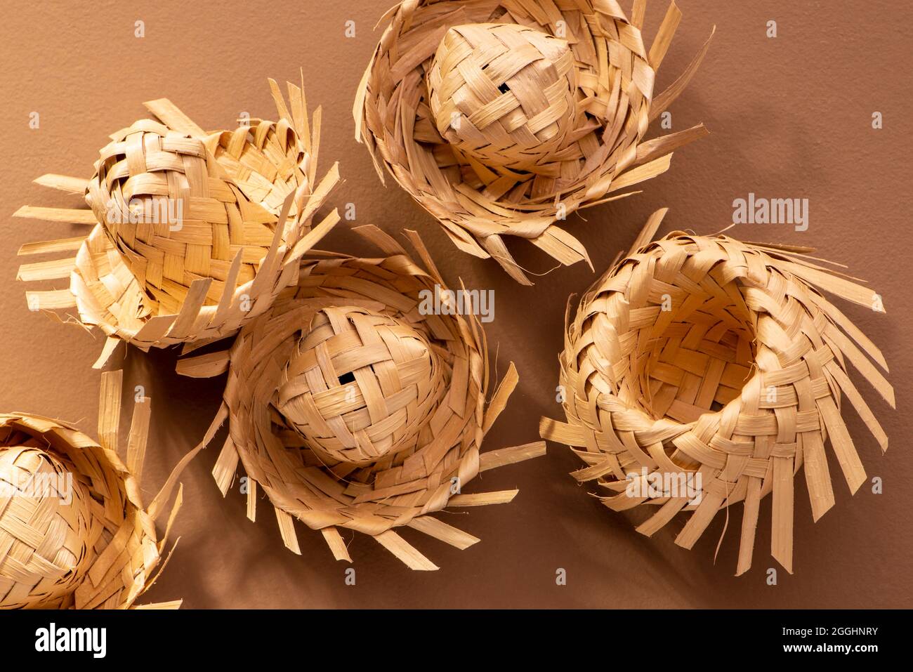 cappelli di paglia piccoli usati per ornamenti di festa junina su sfondo marrone. Foto Stock